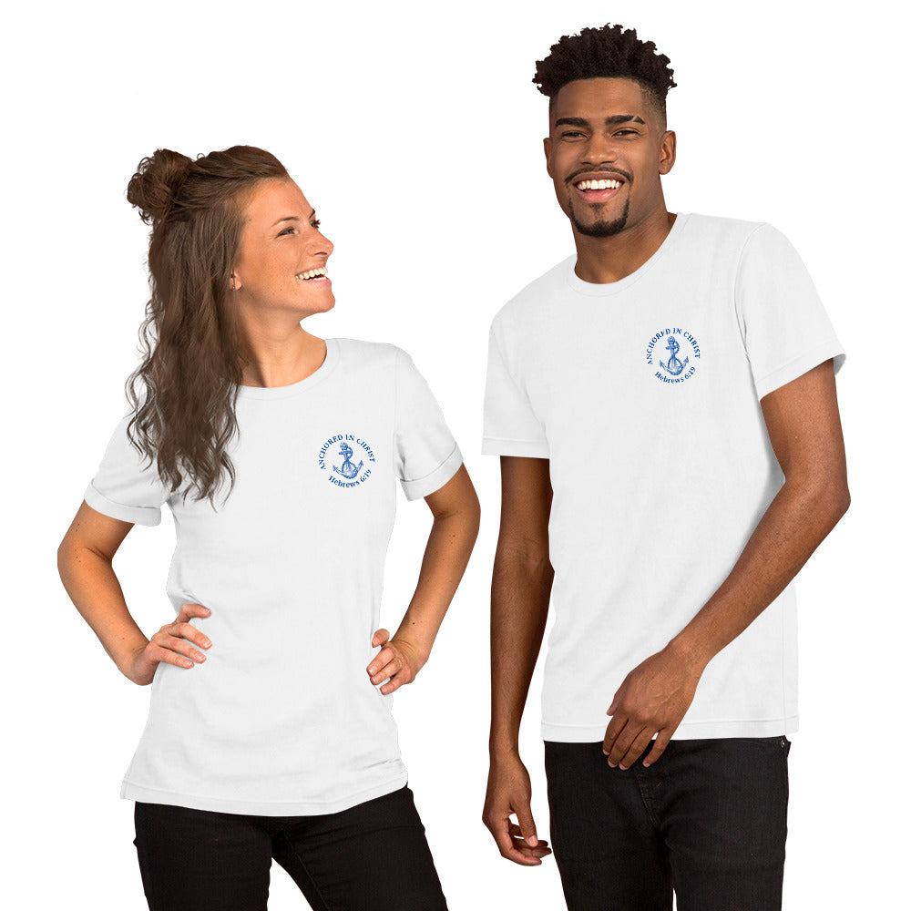 Front view of a couple wearing matching white Christian t-shirts with blue left-chest design featuring an anchor and the words “Anchored in Christ” with Hebrews 6:19.