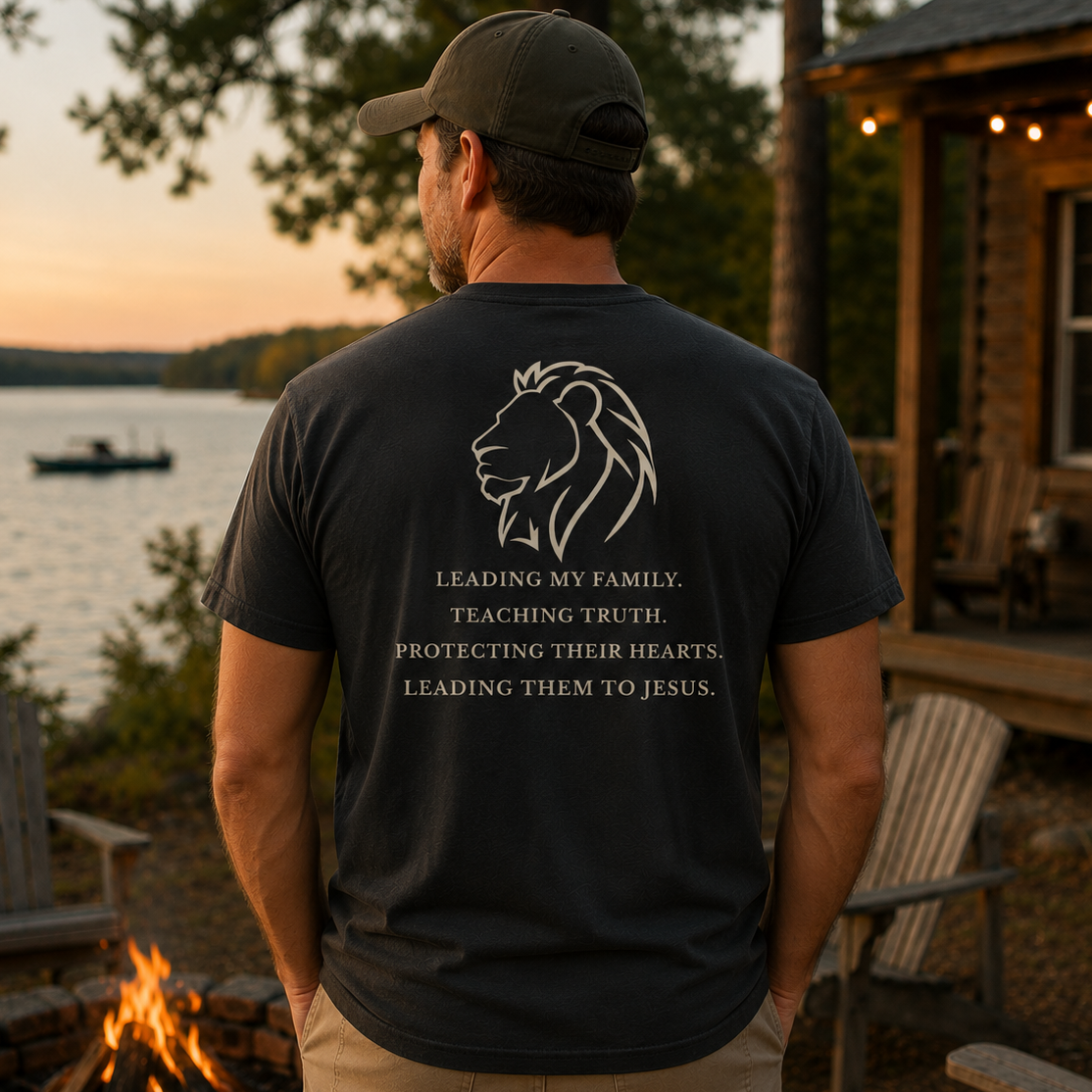 Back view of a man wearing the Lead Teach Protect Tee in Black Rock featuring a lion graphic and the message Leading My Family, Teaching Truth, Protecting Their Hearts, Leading Them to Jesus.