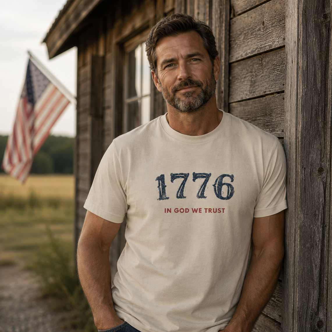 Man wearing the USA 1776 Tee in Dyed Stone featuring 1776 and In God We Trust on the front.