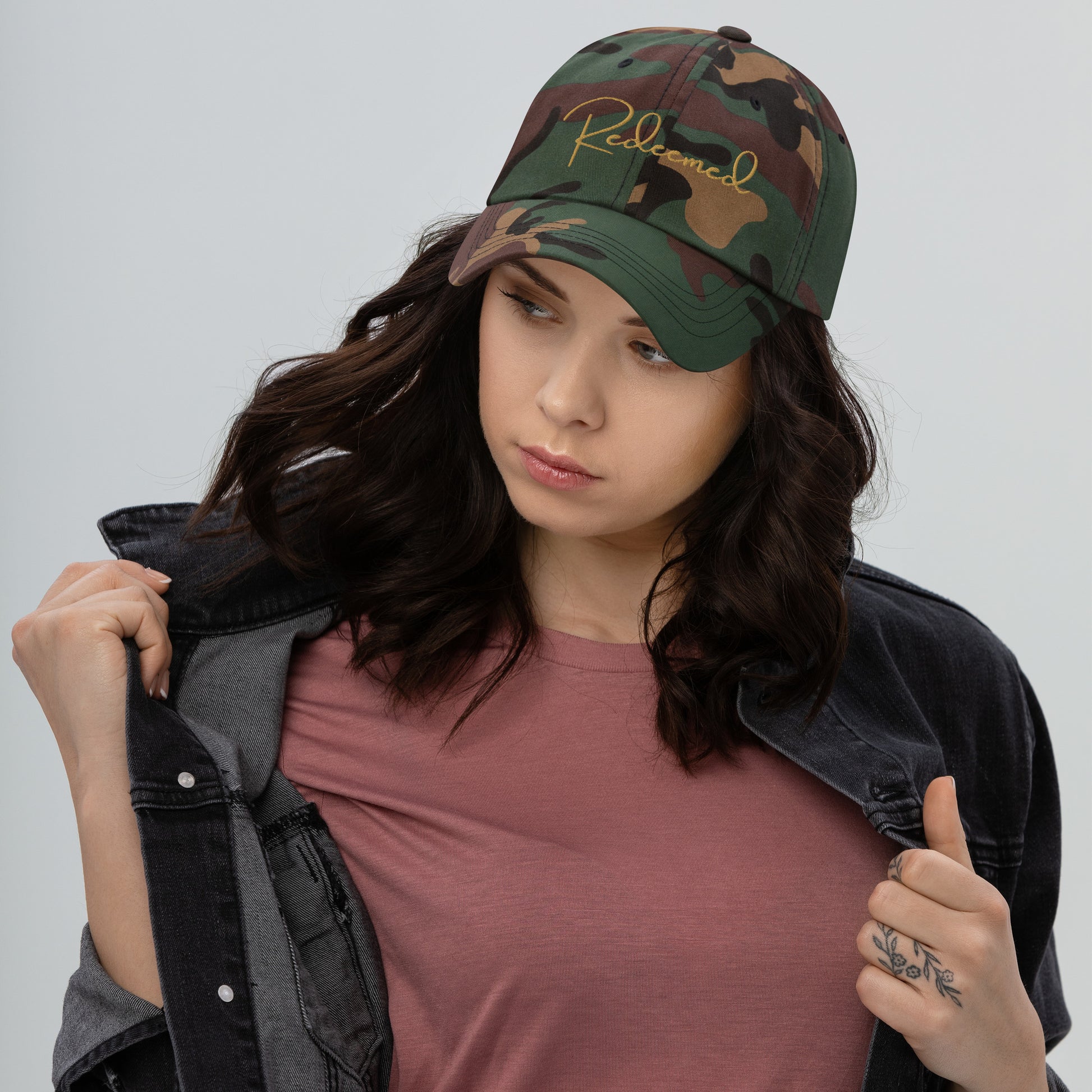 Female model wearing gold embroidered Redeemed hat, styled with neutral tones and soft lighting.