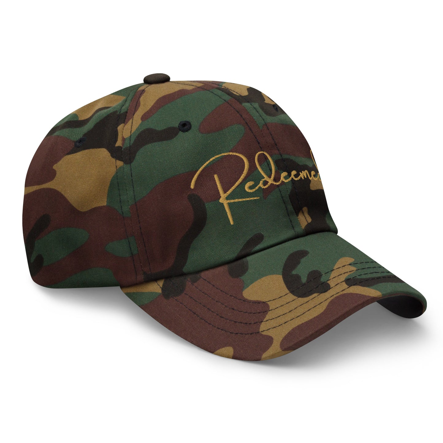 Left front angled view of camo dad hat with gold “Redeemed” text, showcasing shape and texture.
