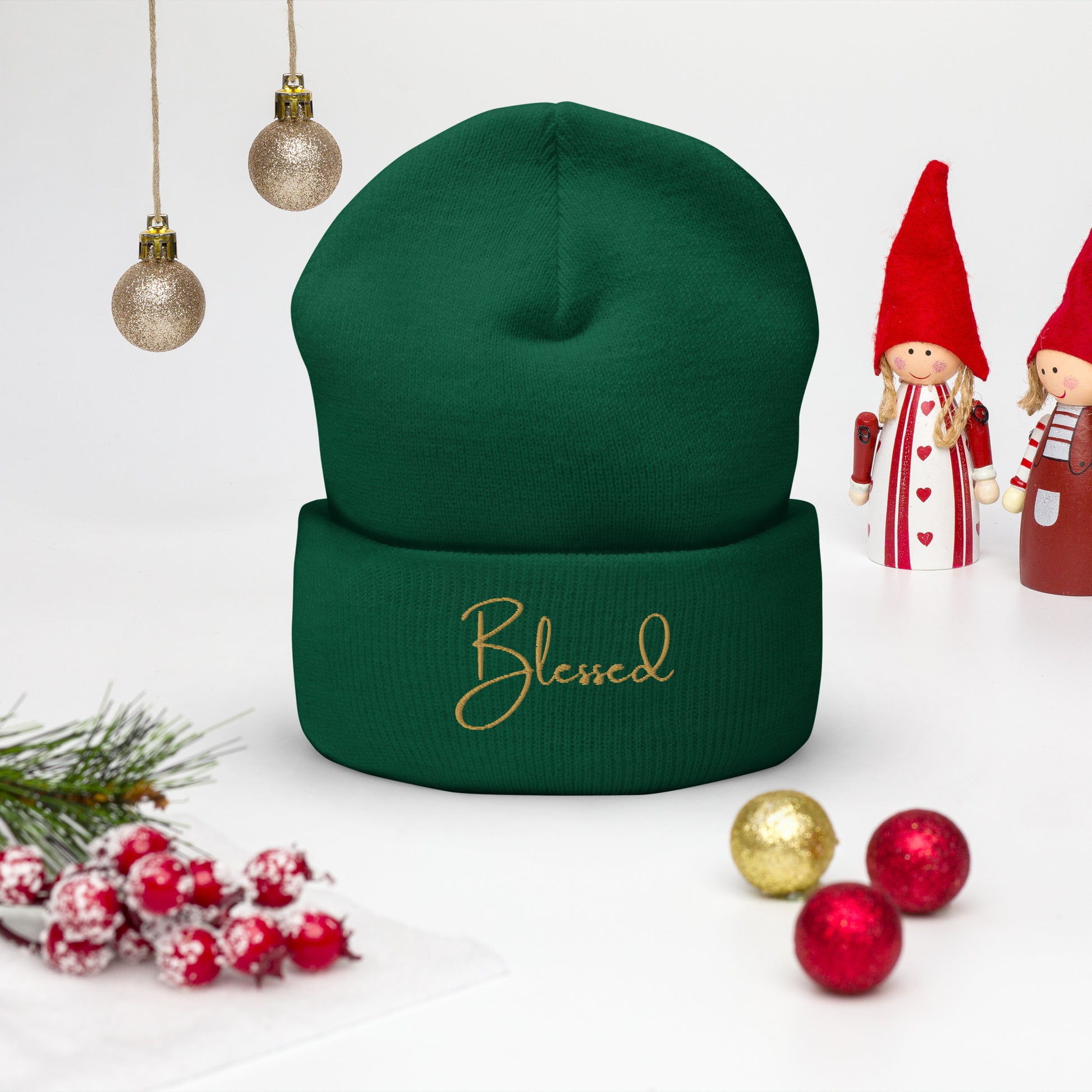 Front view of forest green Blessed beanie with gold embroidery.  Christmas background