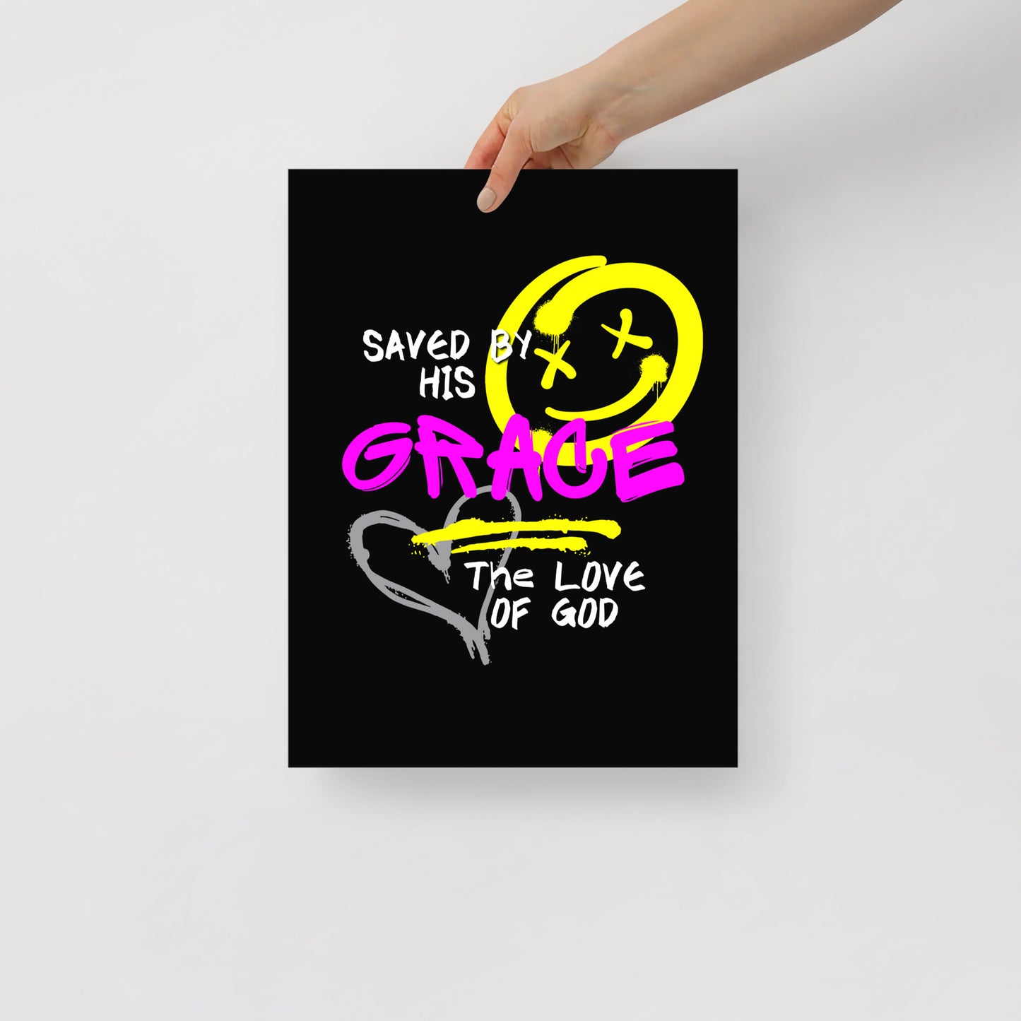 Person holding 12x16 Saved by Grace unframed Christian poster, showing bold graffiti-style text and street-art inspired design

