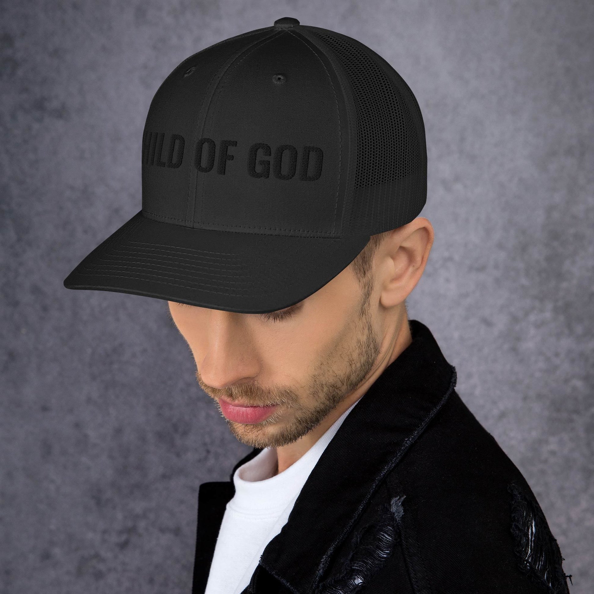 Man wearing black on black Child of God trucker hat in everyday lifestyle setting