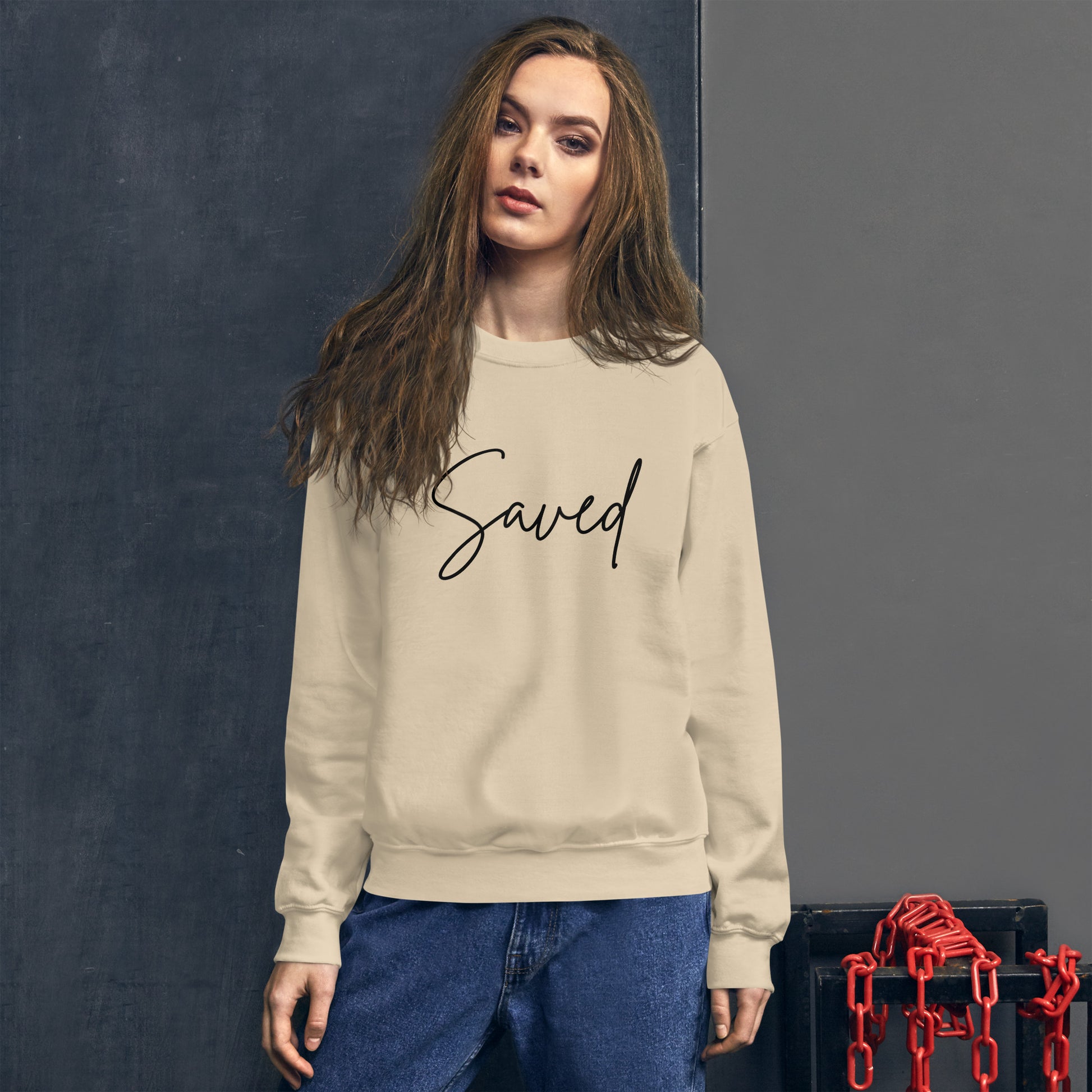 Female model wearing sand Saved crewneck in a cozy lifestyle setting, soft lighting, and peaceful expression
