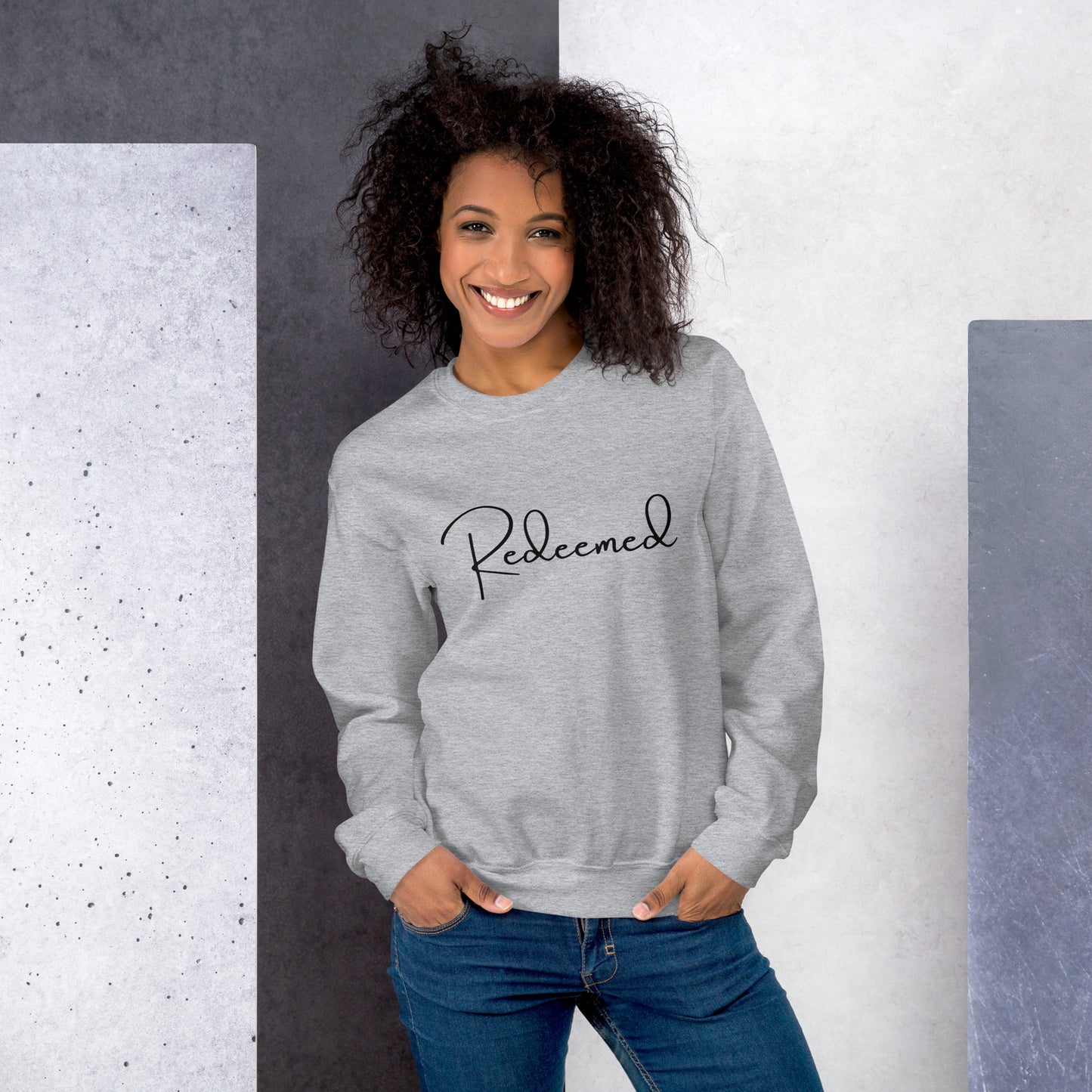Front view lifestyle image of woman wearing Sport Grey Redeemed sweatshirt in casual urban setting.