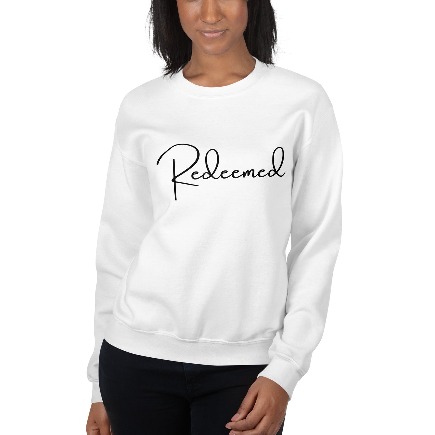Woman wearing the Redeemed crewneck sweatshirt in White, soft lighting, natural lifestyle pose.