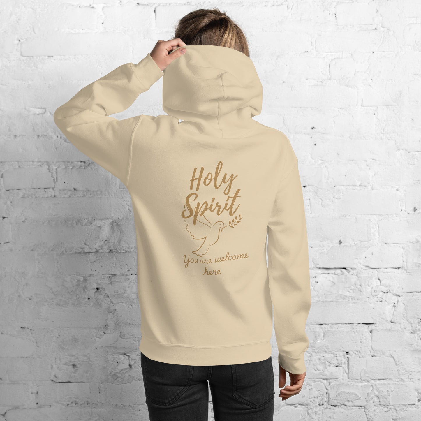 Female model wearing sand-colored Holy Spirit hoodie, back view with large “Holy Spirit” text, dove graphic, and “You Are Welcome Here” script – faith-based clothing

