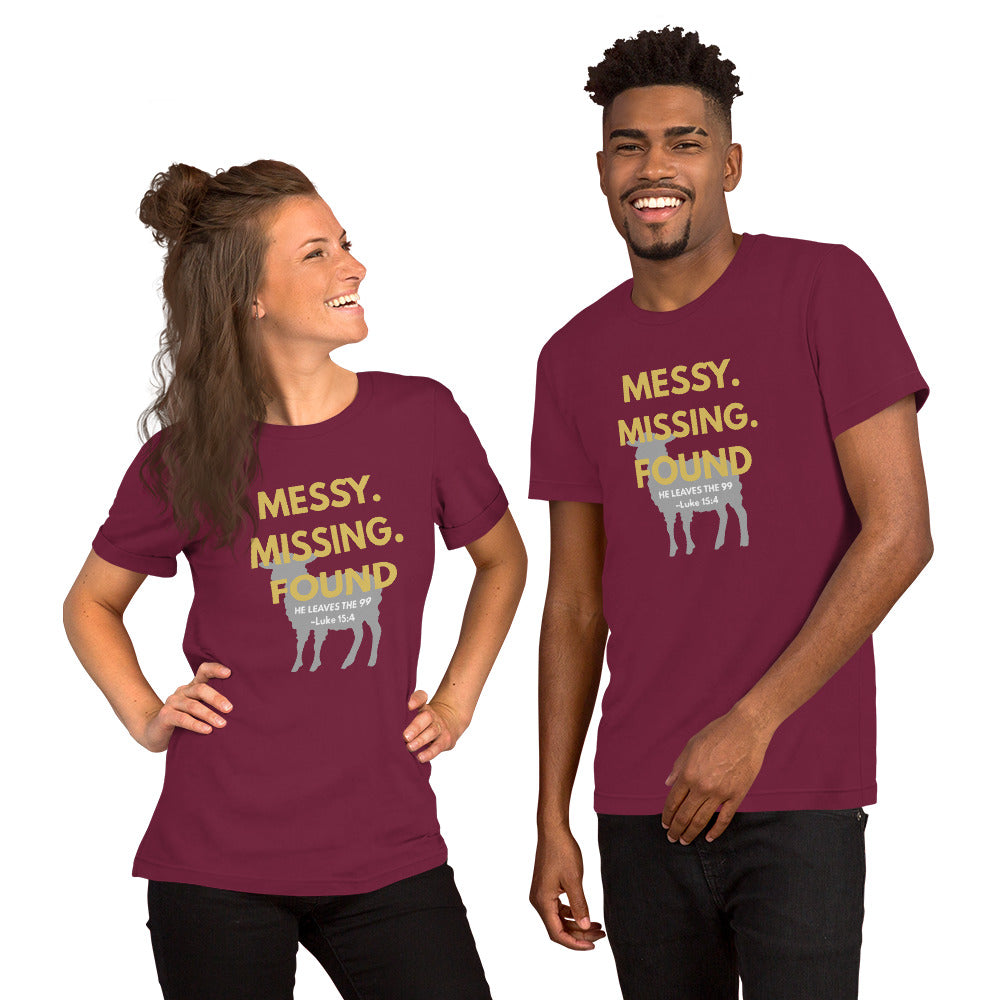 Happy couple wearing matching maroon “Messy. Missing. Found.” t-shirts, smiling together and showing bold yellow front print with Luke 15:4 and lamb silhouette
