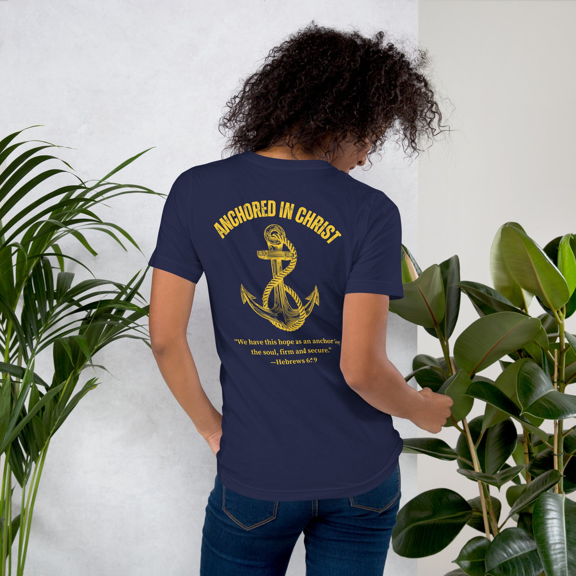 Female model lifestyle photo, back view wearing the Anchored in Christ – Deep Waters Edition tee.