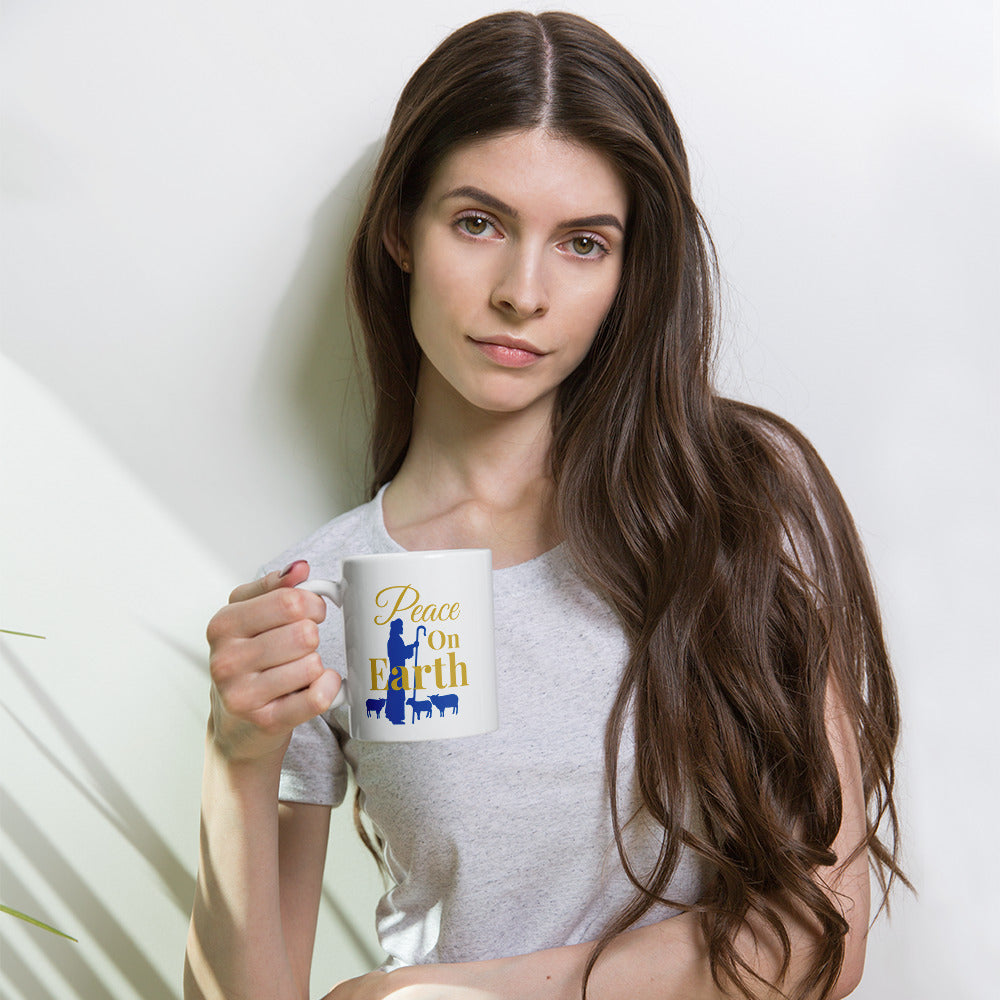 Woman holding Peace on Earth Christmas mug with shepherd and sheep design, enjoying coffee or tea
