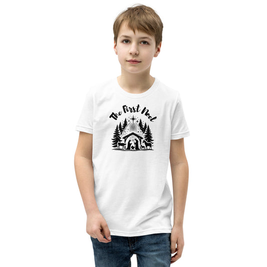 Youth white Christian Christmas tee with black nativity design and The First Noel text inspired by Luke 2:11.
